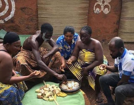 Family sharing a meal around one bowl