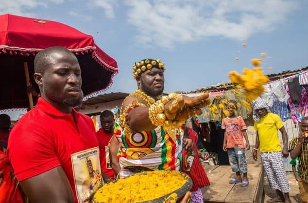 Chief sprinkling festive food in a street procession